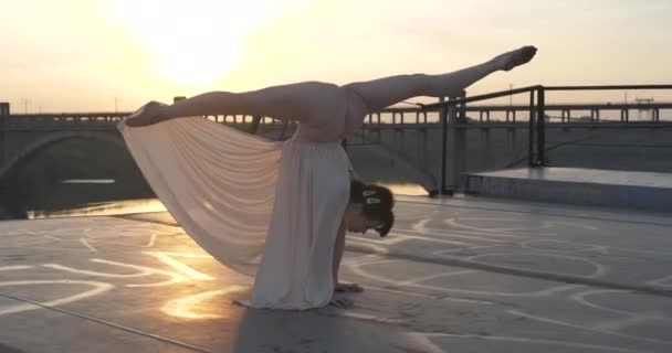 Trik akrobatik. Gadis atlet membuat bentuk senam yang indah. Tali di tangan saat matahari terbenam — Stok Video