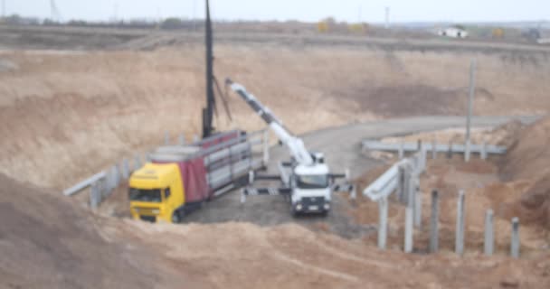 Bouw van een nieuwe snelweg. Wazig materiaal zonder herkenbare merken van apparatuur — Stockvideo