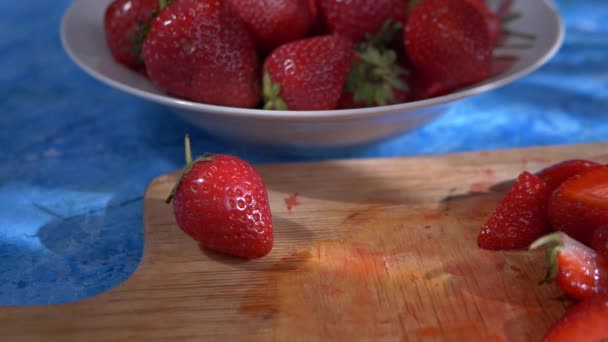 Bagas de morangos vermelhos suculentos em uma placa de madeira. O conceito de uma dieta saudável, frutas e vitaminas. Café da manhã saudável . — Vídeo de Stock