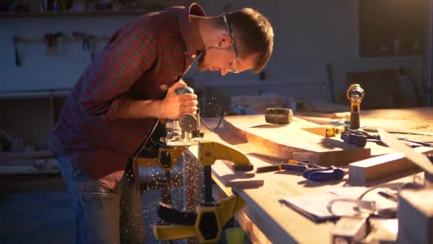 El carpintero trabaja como fresador eléctrico automático para madera en su taller . — Vídeos de Stock
