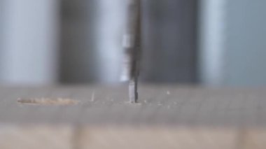 Tahta bir iş parçasının süper makro yavaş çekim delme işlemi.