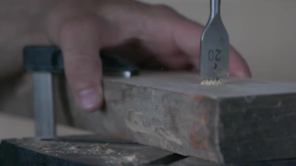 De timmerman werkt met een boor op hout. Super langzame draaibeweging van de boor in het materiaal. — Stockvideo