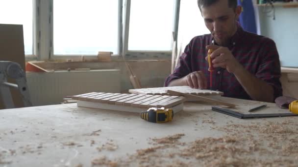 Еко-іграшки та музичні інструменти з дерева. Майстер столяр робить ксилофон ручної роботи для дітей . — стокове відео