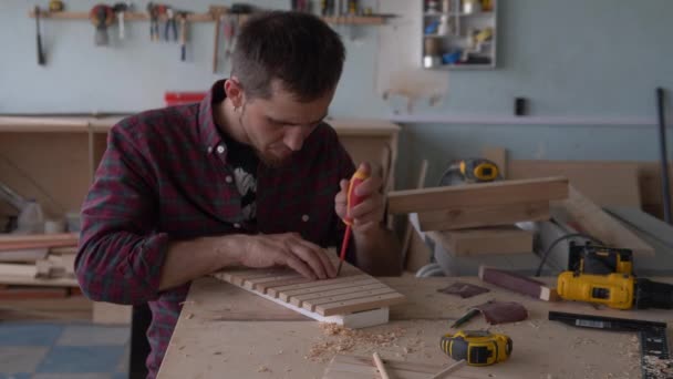 Eco speelgoed en muziekinstrumenten gemaakt van hout. Een meester timmerman maakt een handgemaakte xylofoon voor kinderen. — Stockvideo