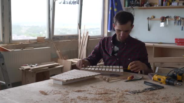 Eco jouets et instruments de musique en bois. Un maître charpentier fabrique un xylophone fait main pour les enfants. — Video