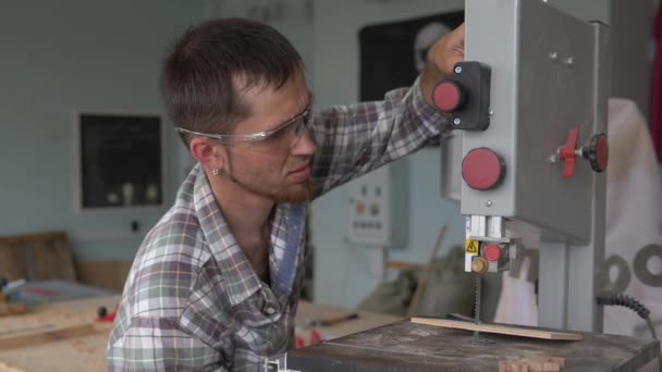 Band-saw . Woodworking. A young carpenter works in his private workshop. — Stock Video