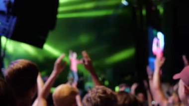 Açık hava konserinde hayran tezahüratı, kollarda hareket bulanıklığı. Bulanık Müzik Festivali. Sahnede lazer gösterisi. Hayranların kalabalığı.