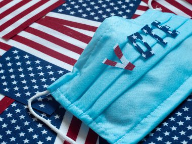 Seçim oylaması. ABD seçimleri. Amerikan bayraklarının arkasındaki virüse karşı tıbbi koruyucu maske