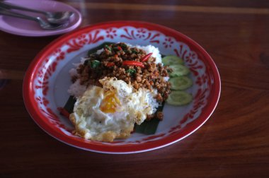 Tavada kızartılmış domuz eti ve fesleğen içinde büyük bir tepsi ile tepesinde pirinç.