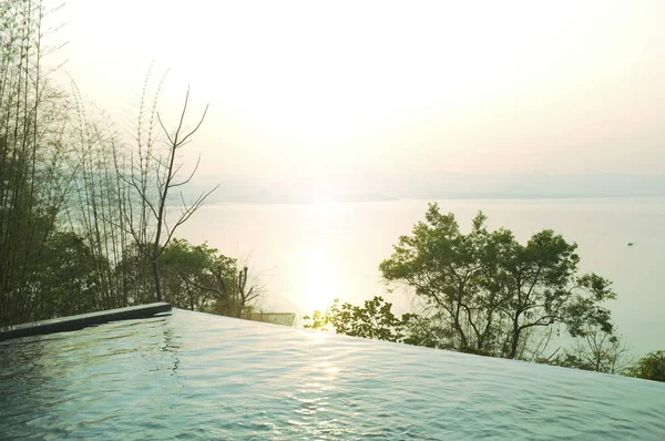 Terrazza con piscina e splendida vista sulla natura, tramonto sul parco nazionale Khuean Srinagarindra a Kanchanaburi, Thailandia e cielo per viaggiare in vacanza tempo di relax — Foto Stock