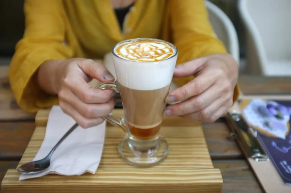 Karamel Macchiato 'nun el ele tutuşan kadını. — Stok fotoğraf