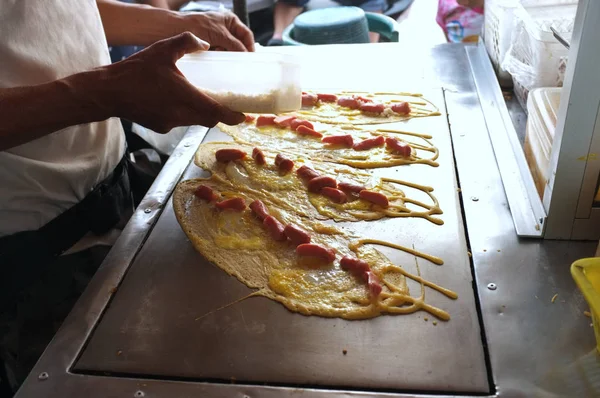 El hombre que cocina el gofre suave, tortita del rollo rellena con la carne de cerdo con la natillas y eeg, postre tailandés . —  Fotos de Stock