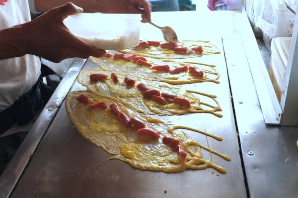 El hombre que cocina el gofre suave, tortita del rollo rellena con la carne de cerdo con la natillas y eeg, postre tailandés . — Foto de Stock