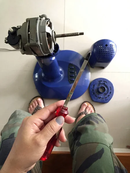 Mujer sosteniendo la mano y utilizando el destornillador para reparar el ventilador electrónico. Mantenimiento — Foto de Stock