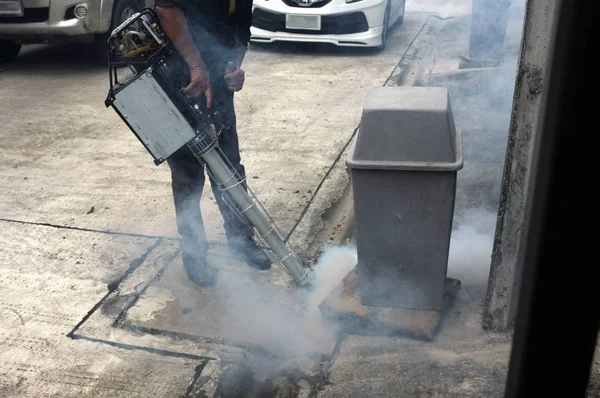 Worker fogging residential  and Sanitary Sewer area with insecticides to kill aedes mosquito breeding ground, — Stock Photo, Image