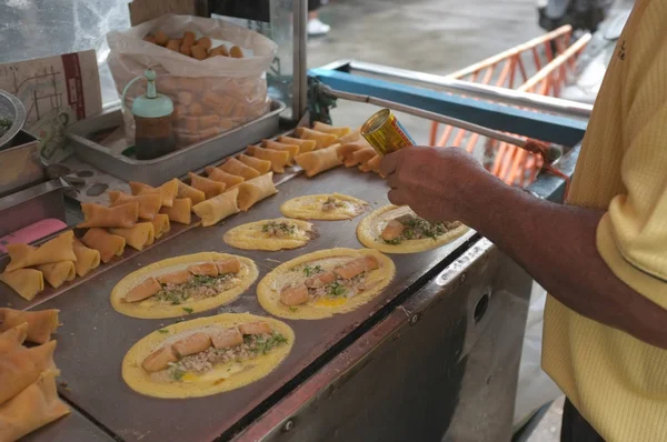 Der Mann kocht weiche Waffel, Rollpfannkuchen gefüllt mit Schweinefleisch mit Pudding und Eeeg, Thai-Dessert. — Stockfoto