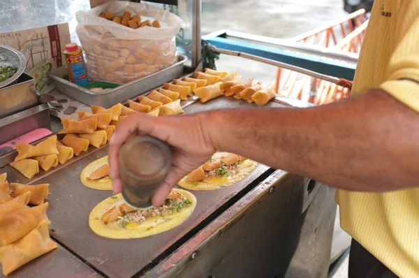 Der Mann kocht weiche Waffel, Rollpfannkuchen gefüllt mit Schweinefleisch mit Pudding und Eeeg, Thai-Dessert. — Stockfoto