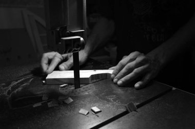 Marangoz üreticisi elektrikli yapboz ve ahşap ile çalışıyor. Ahşap işçisi bir odun parçası kesme  