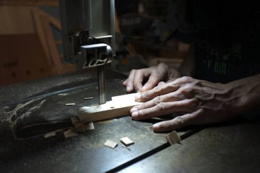 Marangoz üreticisi elektrikli yapboz ve ahşap ile çalışıyor. Ahşap işçisi bir odun parçası kesme  