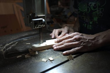 Marangoz üreticisi elektrikli yapboz ve ahşap ile çalışıyor. Ahşap işçisi bir odun parçası kesme  