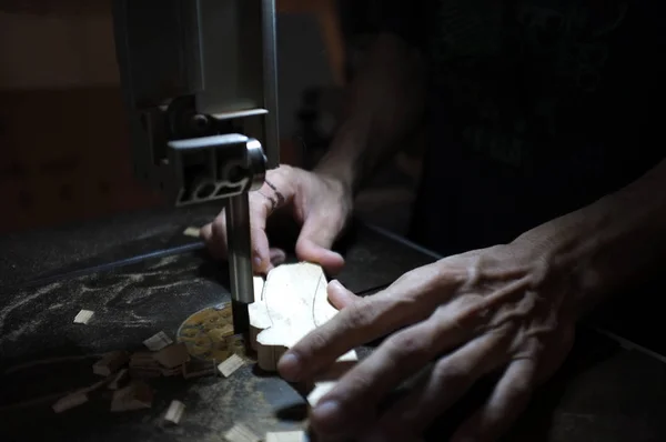 Schreiner, der mit elektrischer Stichsäge und Holz arbeitet. Holzarbeiter, der ein Stück Holz schneidet — Stockfoto