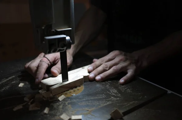 Costruttore di falegnami che lavora con seghetto elettrico e legno. Falegnameria tagliare un pezzo di legno — Foto Stock