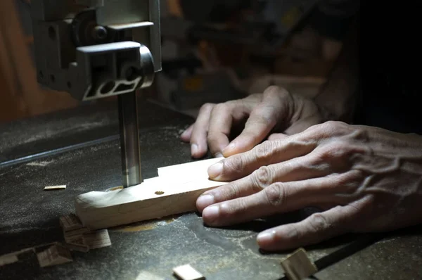 Costruttore di falegnami che lavora con seghetto elettrico e legno. Falegnameria tagliare un pezzo di legno — Foto Stock