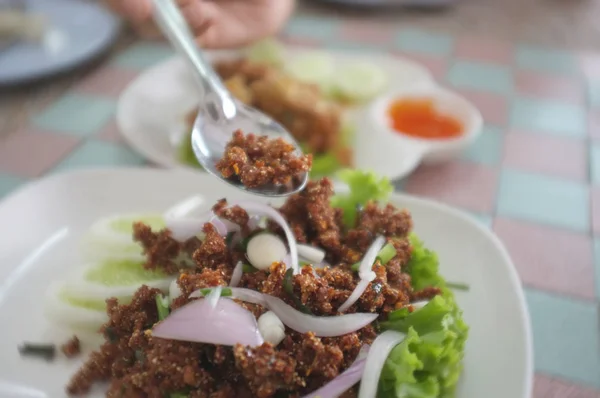 Thai navn er Lab Moo Tod eller Deep stegt krydret hakket svinekød med krydret thai urter - Stock-foto