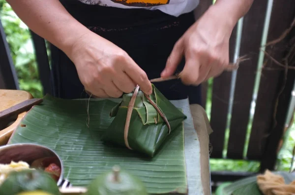 Kvinnan använder naturliga material från bananträd som används för att göra förpackningar för livsmedel. — Stockfoto