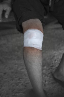 Gri arka planda diz problemi olan adam, yakın çekim  
