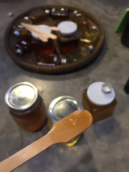 Woman pouring or testing honey. Woman holding dipper with honey , Special light. Copy space. — Stock Photo, Image