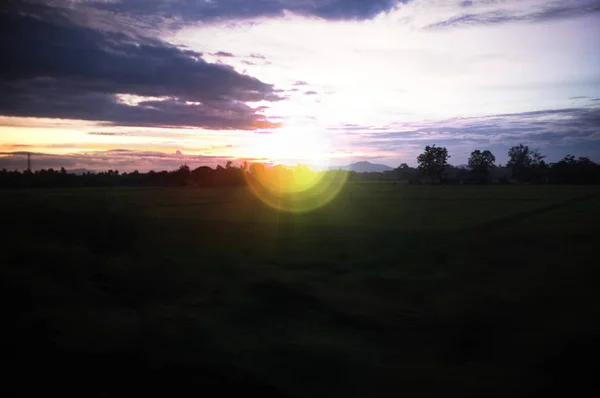 Un colorido amanecer por encima de una pequeña estación de tren en Tailandia, lente Efecto destello — Foto de Stock