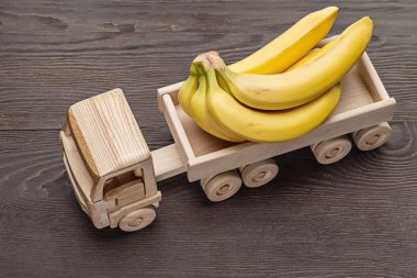 Ahşap oyuncak kamyon salkım muzu taşır. Üstten görünüm, stüdyo vurdu.