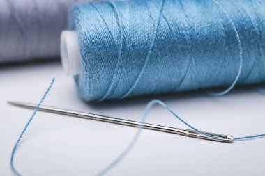 İki iplik bobinleri. Büyük iğneyi mavi thread'dir. Yakın çekim, kopya alanı.