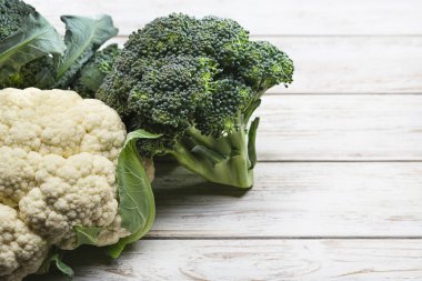 Sağlıklı organik taze karnabahar ve brokoli beyaz tahta masada. Madde, sağlıklı yemekler pişirmek için hazır. Stüdyo vurdu.