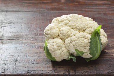 Organik karnabahar koyu ahşap masa üzerinde. Madde sağlıklı yemekler pişirmek için hazır olduğunu. Uzay kopyalayın. Stüdyo vurdu.