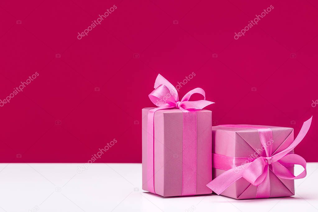 Boxes with gifts in pink packaging, preparation for the holiday. Christmas, birthday on pink background. Copy space.