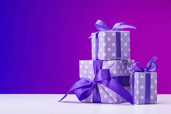 Noel, Doğum günü, yeni yıl hediyesi kümesi. Kutuları zarif mor polka dot gazetede Paketli ve kurdeleler ile dekore edilmiştir. Parlak arka plan, kopya alanı.