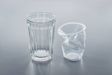 İki bardak, buruşuk plastik ve cam. Yakın çekim, stüdyo vurdu.