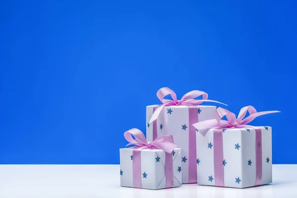 Стильні Коробки Подарунками Білому Папері Зірках Прикрашені Рожевою Атласною Стрічкою — стокове фото