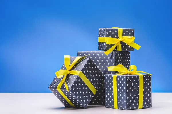 Collection of boxes with gifts for men in elegant paper with yellow ribbon, for celebrating birthday, Christmas, Valentine, parties, anniversaries and celebrations. Copy space.
