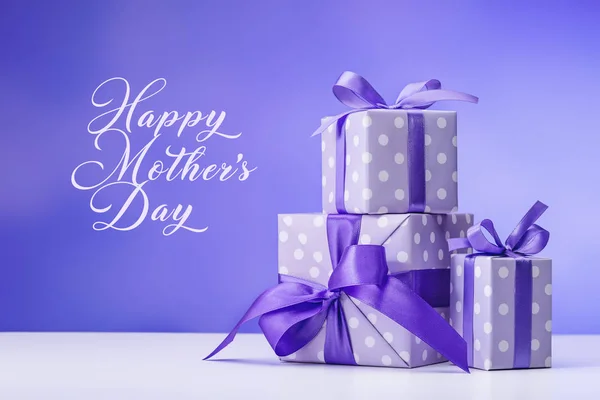 Gifts for Mother\'s Day. Stylish handmade gift box in purple polka dot paper, with a purple bow. Copy space.