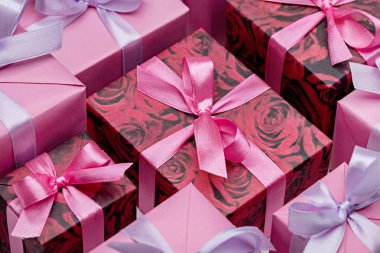 Beyaz arka plan üzerinde, pembe tonlarda, kurdeleler ile renkli hediye kutuları ayarlayın. Metin için alan kopyalama.