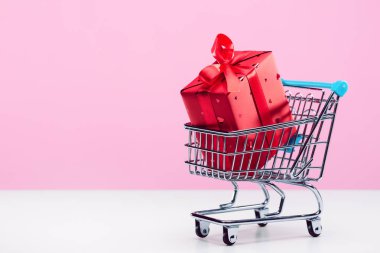 Hediye kutusu, şenlikli ambalaj, oyuncak alışveriş arabası kurdele ve yay ile dekore edilmiştir. Kopyalama alanı.