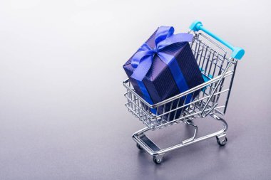  Mavi kağıtta paketlenmiş hediyelerle dolu bir sepet (oyuncak). Uzayı kopyala İndirim, satış..