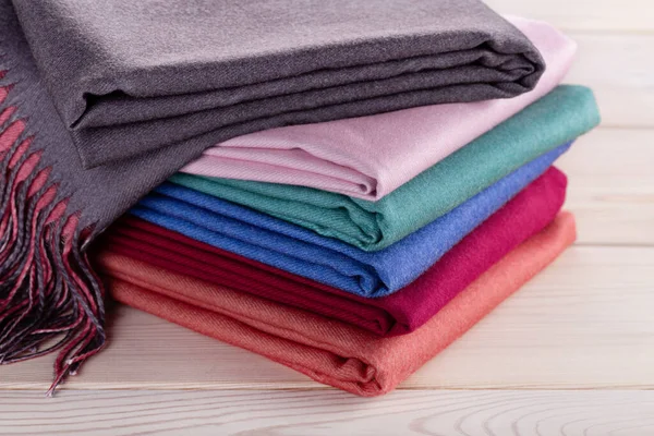 A neatly stacked stack of cashmere shawls, scarves in multi-colored colors. Women\'s accessory, gift souvenir.