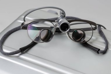 Profesyonel aletler. Aydınlatılmış diş dürbünü büyüteci, metal kutuda, yakın plan..