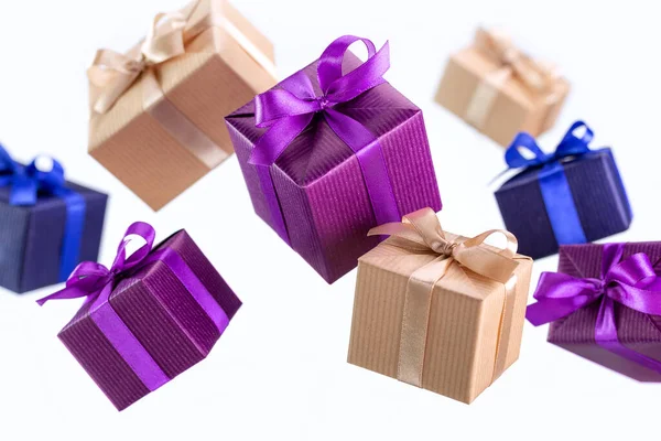 Hediye. Zarif kağıtta uçan kutular kurdeleyle bağlanmış, arka planda fiyonk var, izole edilmiş. Tatiller ve tebrik kartı kavramı.