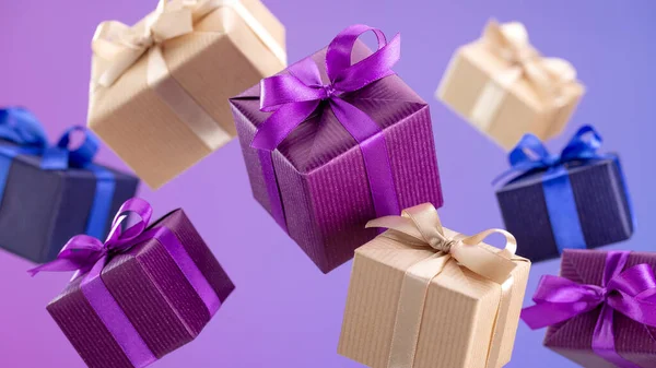 礼物装在飞盒中 用蓝色 紫色和牛皮纸包裹 背景为紫丁香色 — 图库照片