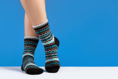Saf çoraplı kadın bacakları, mavi arka plan. Rahatlama ve rahatlama kavramı.